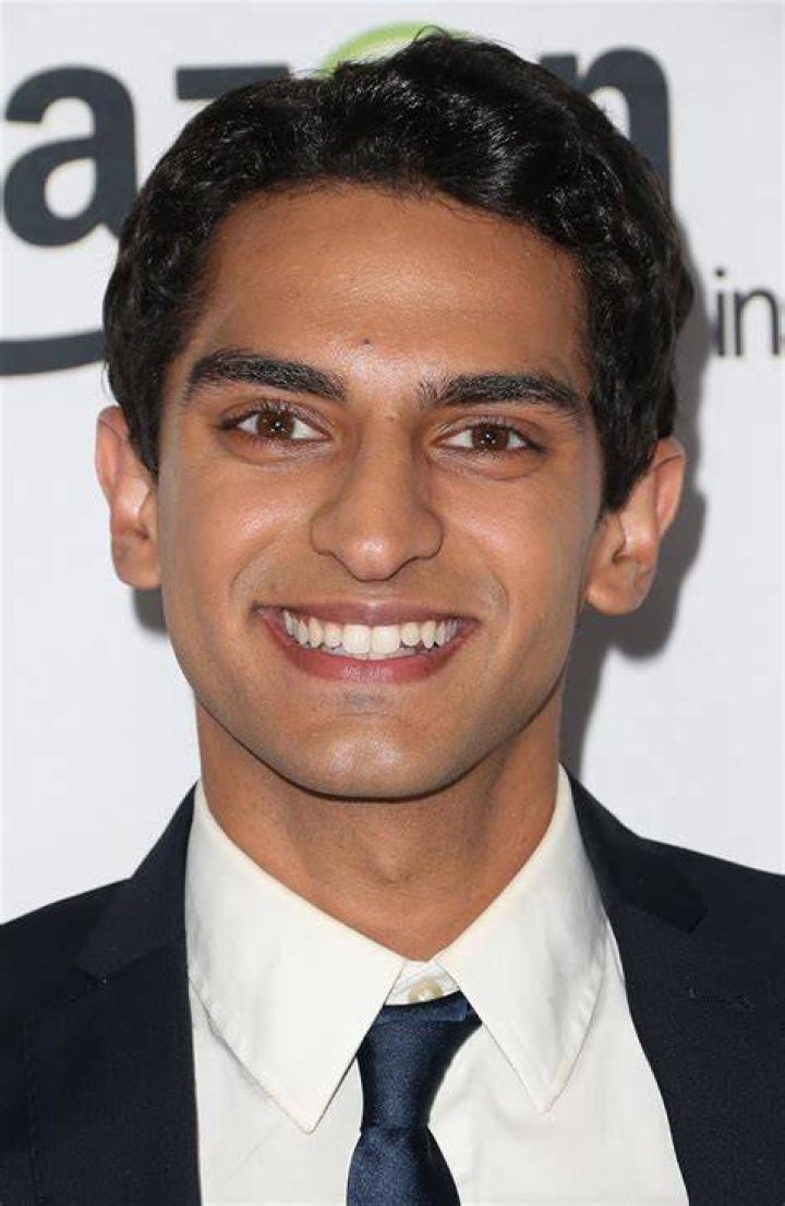 Karan Soni Karan Soni wearing a brown suit jacket and black jumper