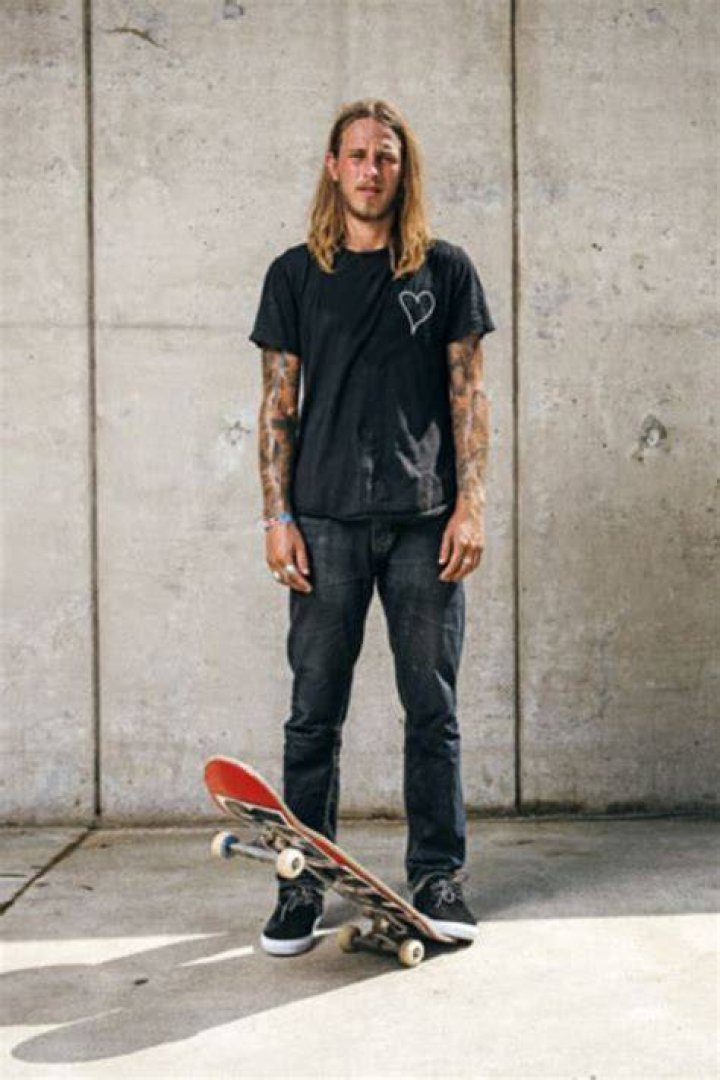 Riley Hawk Posing In A Park With His Skateboard